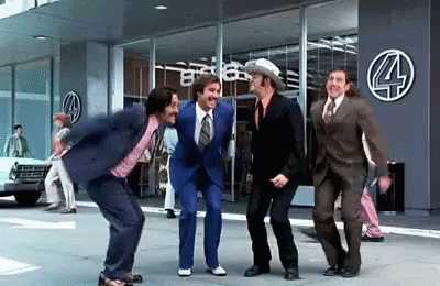 Men in Suits Dancing in Front of Building