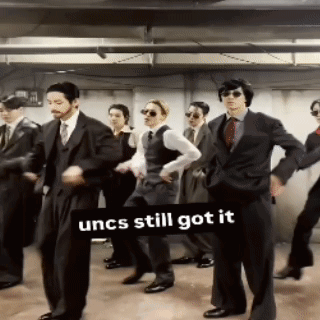 Men in Suits Dancing Under Uncs Still Got It Sign