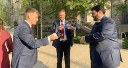 Men In Suits Standing On Sidewalk GIF