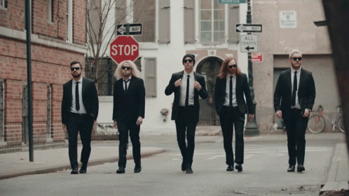 Men In Suits Walking Past Stop Sign GIF