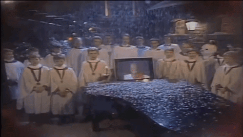 Men in White Robes Around Table With Picture