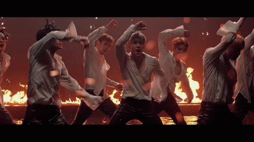 Men in White Shirts Dancing in Front of Fire