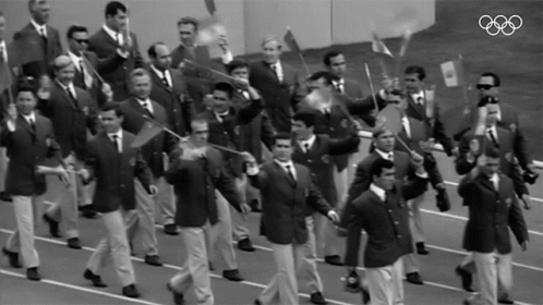 Men Marching in Parade With Olympic Rings