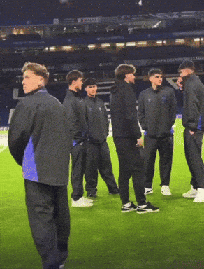 Men on Soccer Field With UEFA Champions League Sign