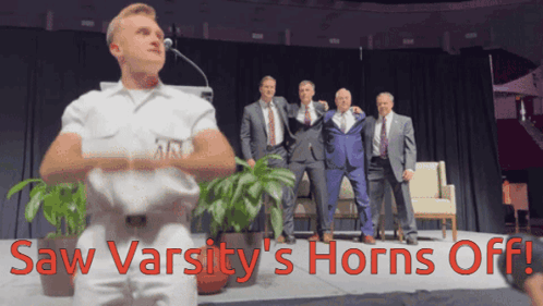 Men on Stage Saw Varsity's Horns Off in Red