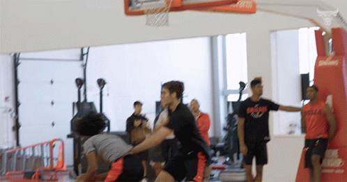 Men Playing Basketball One Wearing Bulls Shirt GIF
