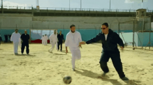 Men Playing Soccer in Sand