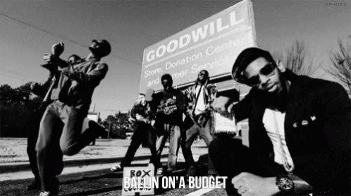 Men Posing in Front of Goodwill Sign