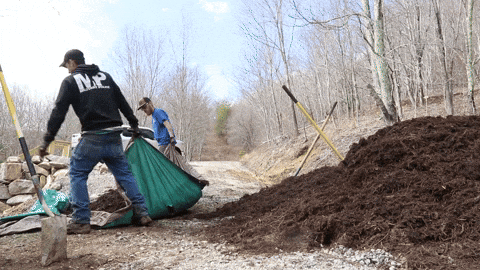 Men Pulling Tarp Containg Mulch GIF