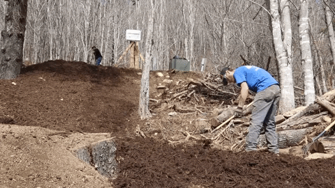 Men Raking Mulch Up And Down A Hill GIF
