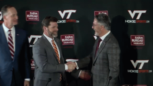 Men Shaking Hands in Front of Farm Bureau Insurance Wall