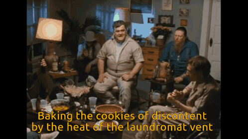 Men Sitting Around Table Baking The Cookies Of Discontent By The Heat Of The Laundromat Vent GIF
