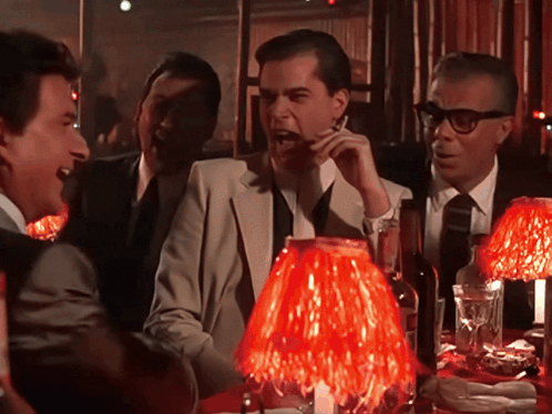 Men Sitting Around Table With Red Lamp