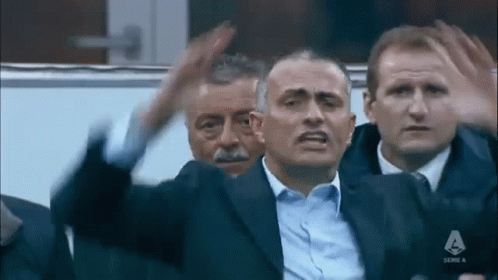 Men Sitting in Stadium One in Suit