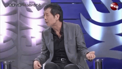 Men Standing And Talking One Pointing At Camera GIF