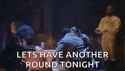 Men Standing Around Table Saying Let's Have Another Round Tonight