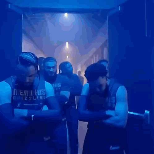 Men Standing Crossed Arms In Dark Hallway GIF