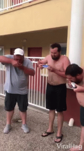 Men Standing In Front Of Building On Phones GIF