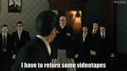 Men Standing In Room With I Have To Return Some Videotapes GIF