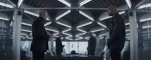 Men Standing in Room with Table and Mirror
