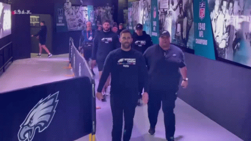 Men Walking Down Hallway With NFL Champions Sign GIF
