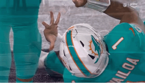 Miami Dolphins Player Giving Peace Sign on Ground