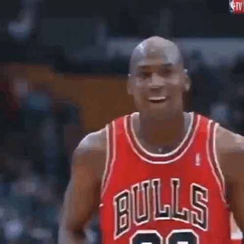 Michael Jordan Is Holding A Basketball In His Hands And Blowing It Up . GIF