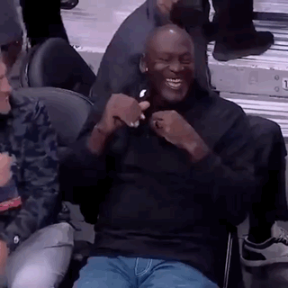 Michael Jordan Is Sitting In The Stands At A Basketball Game Laughing And Holding A Cell Phone . GIF