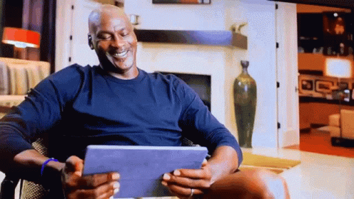Michael Jordan Is Smiling While Looking At His Tablet GIF