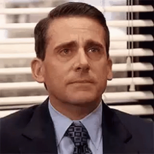 Michael Scott From The Office Is Wearing A Suit And Tie And Making A Funny Face . GIF