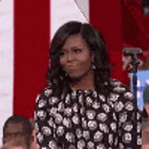 Michelle Obama in Black and White Polka Dot Dress in Front of Red and White Flag