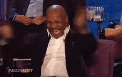 Mike Tyson Is Sitting In A Chair With His Arms In The Air And Smiling . GIF