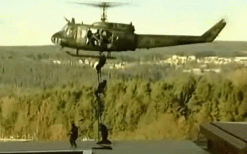 Military Helicopter with Soldiers Hanging from Side