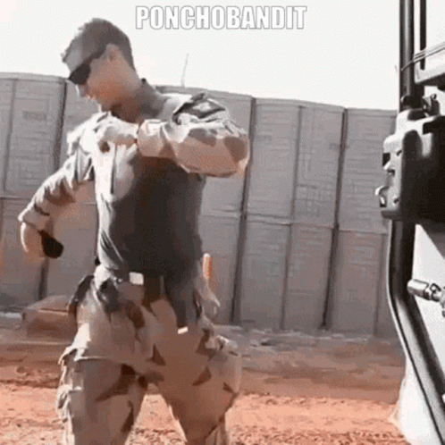 Military Man Standing Before Ponchobandit Wall GIF