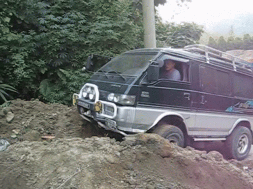 Mitsubishi Van Driving Through Pile of Dirt
