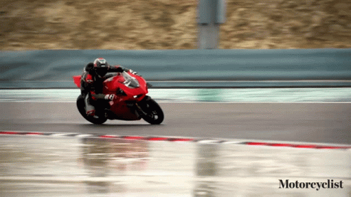 Motorcyclist Riding Red Motorcycle on Wet Track