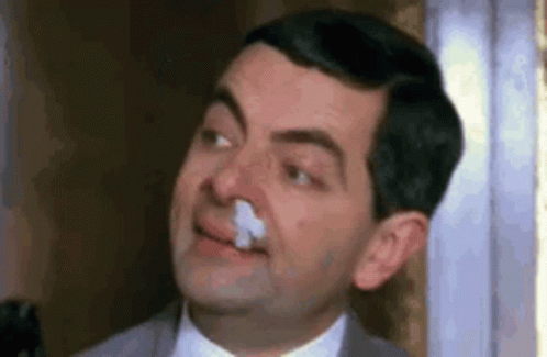 Mr Bean Is Holding A Napkin In His Nose And Smiling . GIF
