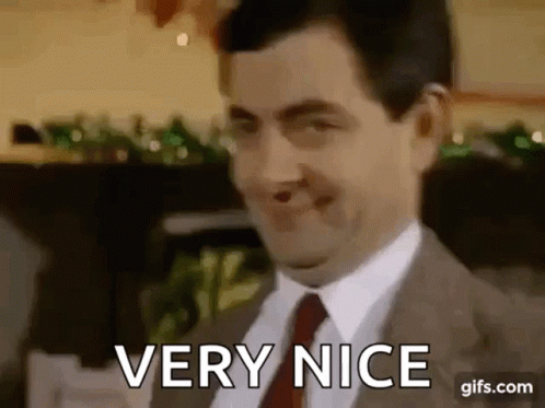 Mr Bean Is Wearing A Suit And Tie And Smiling While Saying `` Very Nice '' . GIF