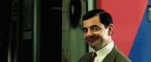 Mr Bean Smiling By Red And Blue Wall GIF