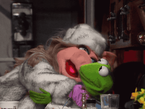Mrs. Piggy And Kermit From The Muppet Show Are Hugging Each Other GIF