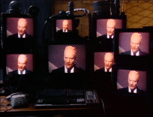 Multiple Monitors With Man In Suit GIF