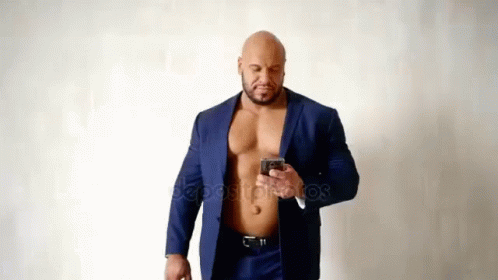 Muscular Man in Suit Without Shirt Using Cell Phone