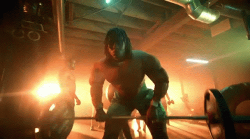 Muscular Man Lifting Barbell Row In The Dark GIF