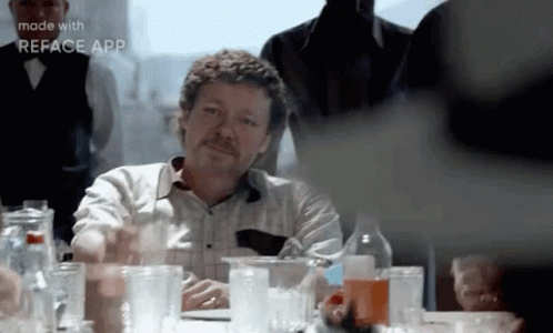 Mustached Man Sitting at Table with Glasses