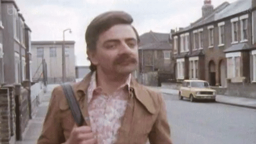 Mustached Rowan Atkinson Striding Happily GIF
