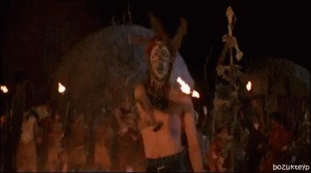 Naked Woman Standing In Front Of Fire In Dark Room GIF
