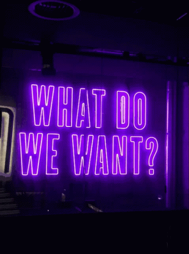 Neon Sign Saying What Do We Want GIF
