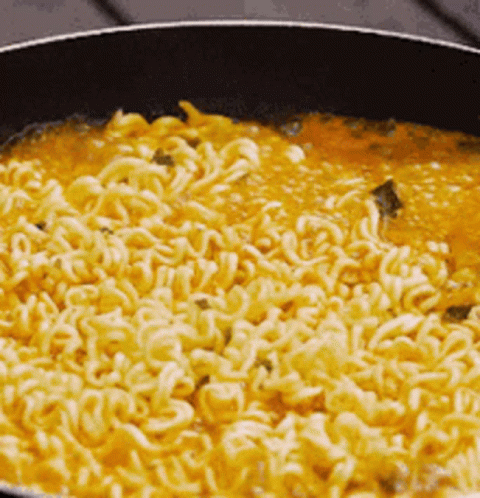 Noodles Are Being Cooked In A Pan With Sauce . GIF