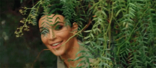 Nosy Kim Kardashian Peeking From Behind The Plants GIF