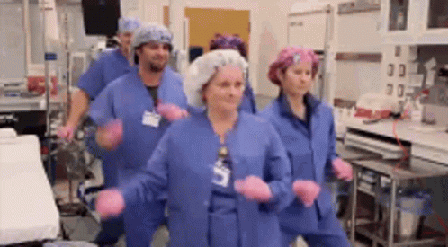 Nurses Dancing in Blue Scrubs and Pink Gloves